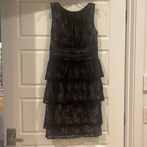 Never worn! Maggie London beautiful lace dress.  Size 8, Black w/ tan lining.